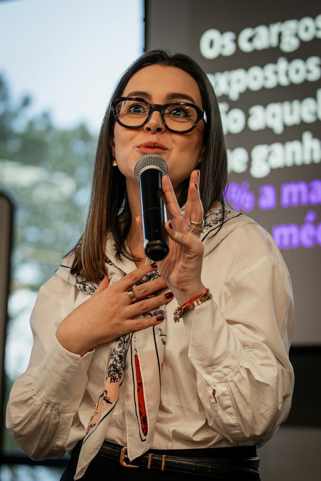 Izabela Anholett falando ao microfone durante um treinamento corporativo